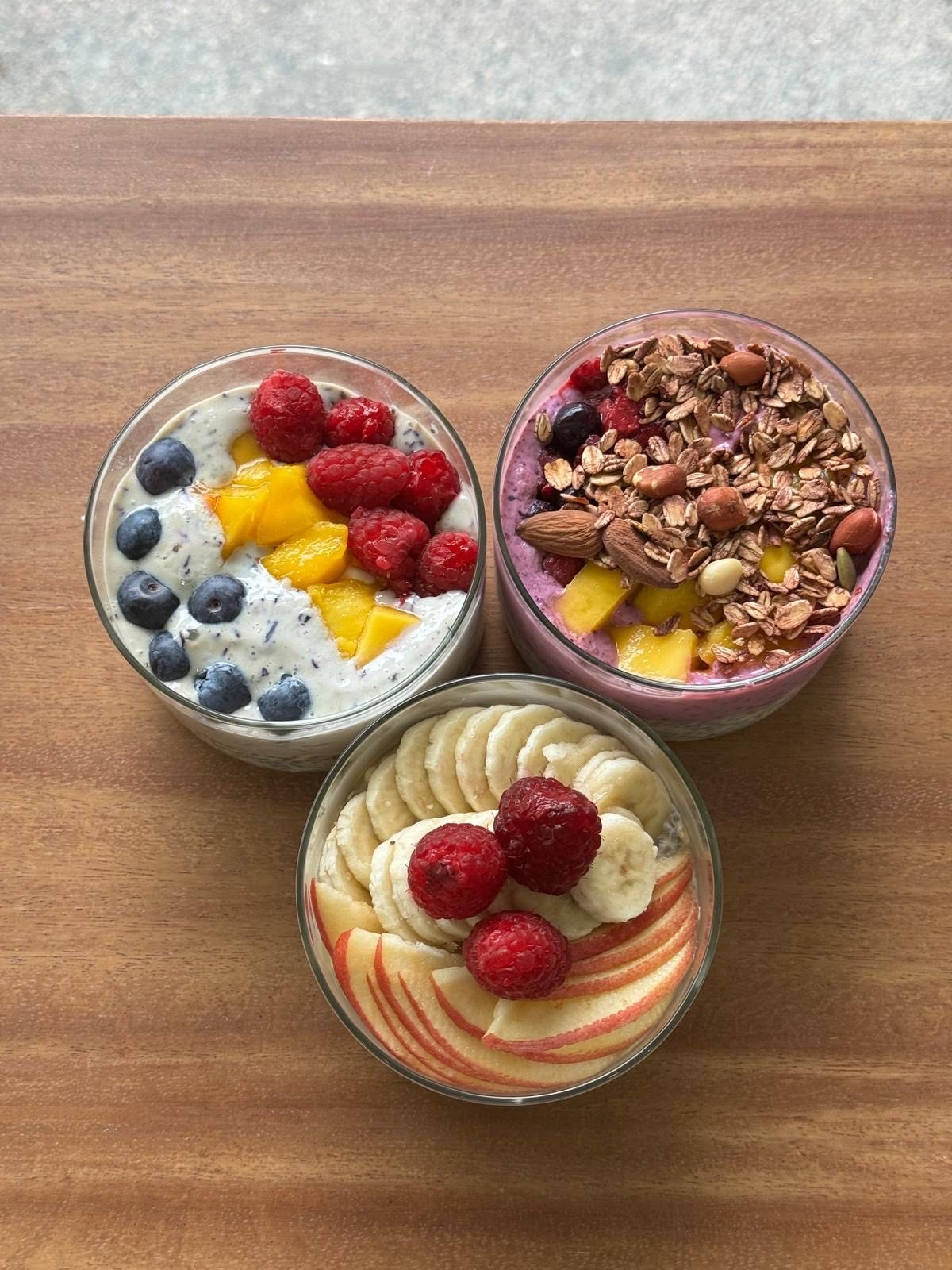 Three chia bowls topped with fresh fruit
