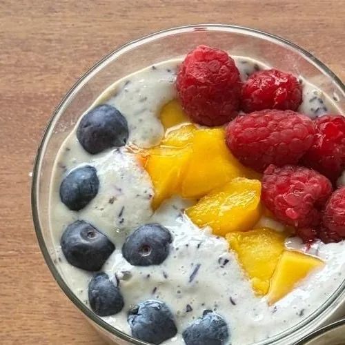 Un bowl individual de pudín de chía con arándanos, mango y frambuesas.