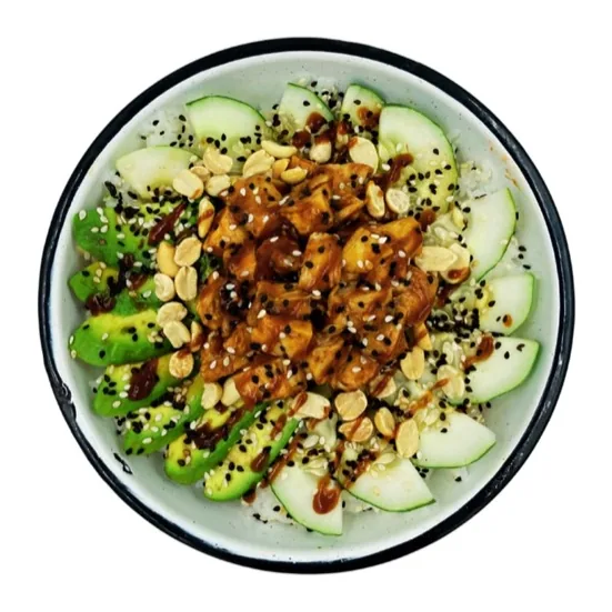 Pollo en cubos con salsa BBQ sobre arroz, con cacahuates, aguacate, pepino y ajonjolí.