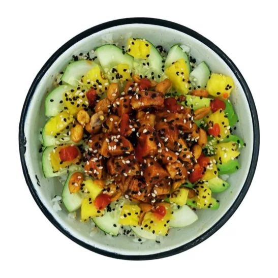 Pollo en cubos con salsa picante, piña, pepino, aguacate, cacahuates y ajonjolí.