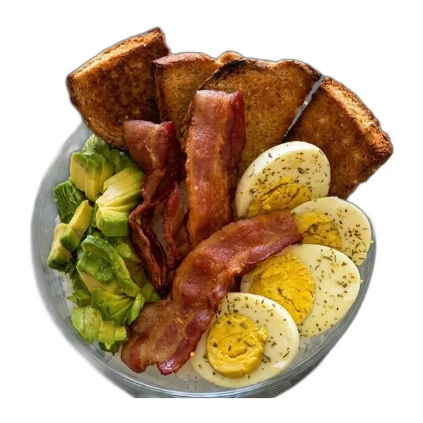 Bowl Protein Poke con tocino, huevo cocido en rodajas, aguacate en cubos y pan tostado.