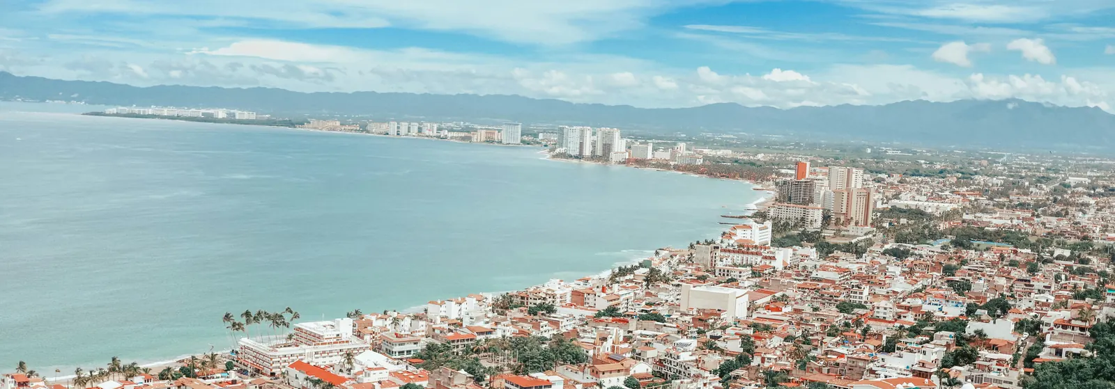 Aerial view of Banderas Bay and the Puerto Vallarta coastline, with the town along the shore and mountains on the horizon